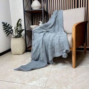 شال مبل تک‌رنگ بافت‌دار سایز دو نفره رنگ طوسی روشن روی مبل راحتی